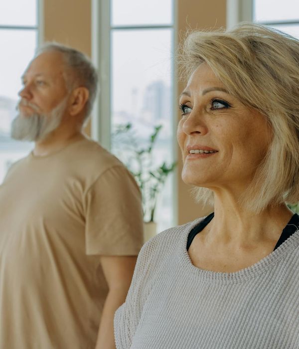 Woman in a calm yoga pose in a softly lit room.